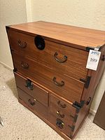 Front view of two stacked Japanese style wooden chests with black metal hardware