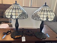 Pair of Tiffany style table lamps on tabletop showing overall size and matching design.