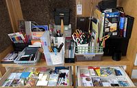 Overview of the main desk area showing baskets and containers filled with various writing instruments, scissors, and office supplies.