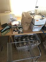 Overview of table with sewing and craft supplies, including storage bins and wicker baskets