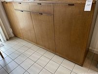Front view showing full length of the buffet with four cabinet doors and two drawers with black recessed handles.