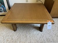 Front view of square table top and four legs with hanging tag