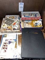 Wide shot showing stamp sheets in trays, loose stamps, and a black binder labeled 'Sheet Holder'.