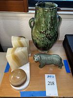 Full lot displayed on wooden surface near window: stone bookends, ceramic vase, ceramic tiger figurine