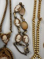 Close-up of vintage cameo bracelet with multiple oval cameos carved in relief set in gold-tone metal.