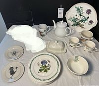 Lot spread showing various Villeroy & Boch floral pieces including platter, covered dish, mugs, small bowls, Christmas handled bowl, and decorative plates on a white cloth background.