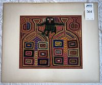 Full view of the framed vintage hand sewn textile art with colorful geometric patterns and central stylized figure.