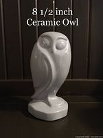 Front view of the ceramic grey owl figurine showing its height and glossy surface.