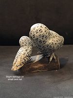 Pair of wooden owls carved and painted by Angawa Art Studio, shown from front angle. Notation of slight damage on the small owl's tail tip.