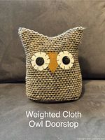 Front view of the owl-shaped weighted cloth doorstop showing texture and details of eyes and beak.