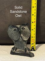 Photo of a solid sandstone owl sculpture with measuring tape for size reference about 6 inches tall