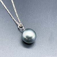 Overall view of the greenish-blue pearl pendant on sterling silver chain.
