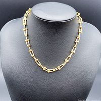 Necklace displayed on black bust, front view showing link style