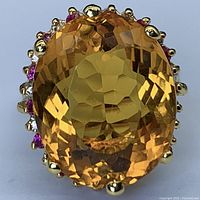 Front view of ring showing large faceted oval citrine and halo setting