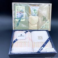 Two boxed sets of cotton face towels, one from T-Life with soap and washcloth, the other Givenchy towels in a gift box.