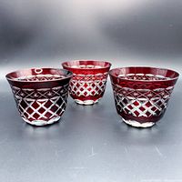 Front view of three red Edo Kiriko cut glasses showing lattice and starburst geometric patterns and clear bases.