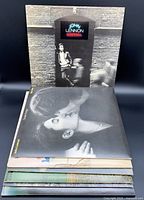 Stack of four John Lennon LP jackets: Rock ’n’ Roll, Double Fantasy, Walls and Bridges insert, Mind Games.