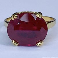 Front view showing oval red gemstone and four-prong setting