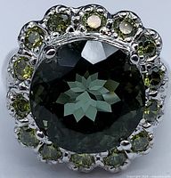 Top-down view of ring showing central round tourmaline and surrounding sapphire halo