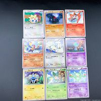 Photo showing nine Japanese Pokémon cards laid out facing up, featuring characters Togepi, Nosepass, Volcarona, Archeops, Togetic, Ralts, Shinx, Simisage, and Reuniclus.