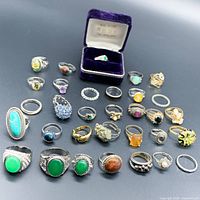 Top view of 32 assorted rings arranged in rows on black background