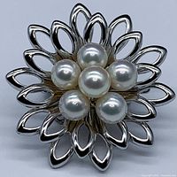 Front close-up of silver floral design brooch with six Akoya pearls clustered in center