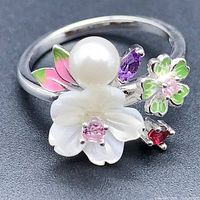 Front view of the flower design ring showing pearl, carved flower, amethyst, rhodolite, and enamel floral details.