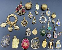 Full lot view with all 21 gold-tone pendant tops arranged on blue background.