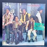 Front album cover of The Jackson 5 Both Sides LP showing the band members posed outdoors on chairs with colorful 1970s clothing.