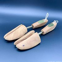 Pair of cedar wood shoe trees with a split-toe front design and adjustable metal mechanism, showing top and toe side views.