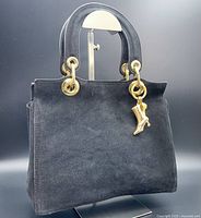 Front suede side of the handbag showing gold-tone hardware and boot charm.