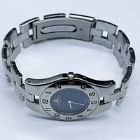 Front angle view showing full stainless steel case, integrated bracelet and blue dial.
