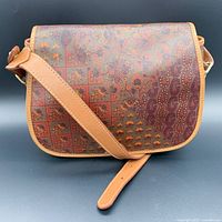 Front view of the vintage ESCADA crossbody bag showing all-over tinted print canvas with leather trim and flap.