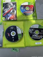 Top view showing Need for Speed Hot Pursuit disc and cover art along with Shift 2 Unleashed disc and case open.