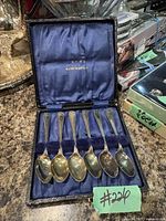 Six silver plate demi tasse spoons arranged in original case with blue satin lining and gold leaf E.P.N.S. marking.