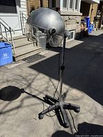 Full view of the silver Babyliss floor hair dryer on black caster base with adjustable shaft and power cord.