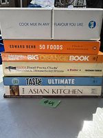 Photo of seven cookbooks stacked including a boxed set titled 'Cook Milk in Any Flavour You Like' and various author and theme cookbooks.