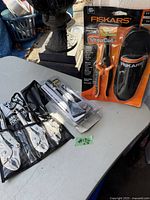 Overview photo of the tools including Fiskars ShopCut shears in packaging and American Pro locking pliers set in pouch.