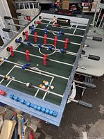 Top view of foosball tabletop game fully assembled with players mounted on rods and scoring beads on side rail.