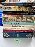 Stack of eleven books with visible titles from various genres and authors