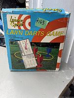Front facing photo of the vintage Lawn Darts Game original box, showing game image, branding, and condition.