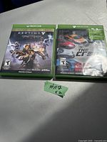 Two Xbox One video game cases: Destiny 2 and The Crew and a small label with #117 x2.