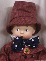Close-up of Effanbee Buddy L doll's face and upper outfit including red hat, blue polka dot bow tie with badge.