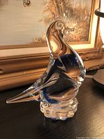 Photo of the blue glass bird figurine from side angle showing the shape and base.