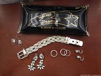 Photo showing all jewelry items and glass dish together on surface.