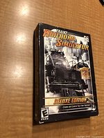 Front box cover of Trainz Railroad Simulator Deluxe Edition PC CD ROM game showing steam locomotive artwork and title.