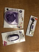 Three Wilton cake decorating tools in original packaging: rotary cutter, rolling cutter, and flower-shaped stencil