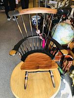 Front angled view of Windsor doll chair showing wooden spindled back, contoured seat, and shaped armrests with black and natural wood finish.
