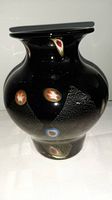 Full view of the black glass vase showing multicolored inlays and bulbous shape.