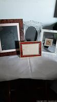 Four assorted old photo frames arranged on a white surface against a white background.
